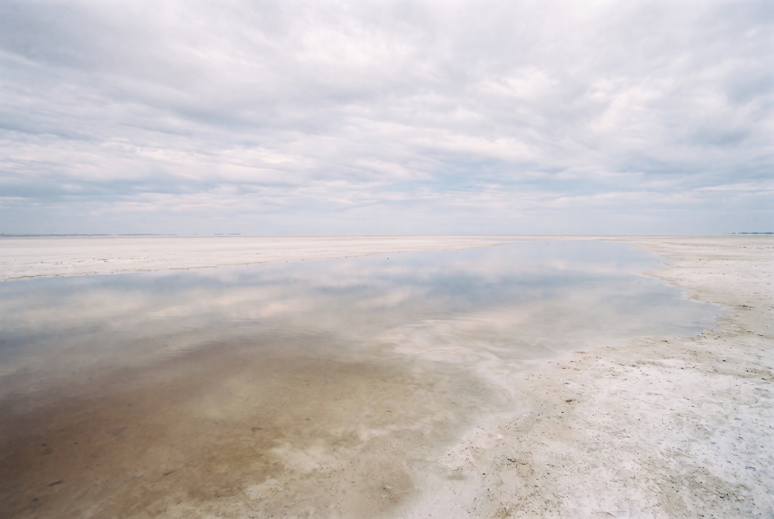 A thin sheet of floodwater spreading across the Makgadikgadi pan, mirroring the sky.